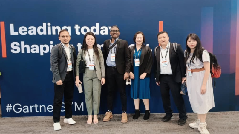 6 people posing for a formal photo at the Gartner IT Symposium.