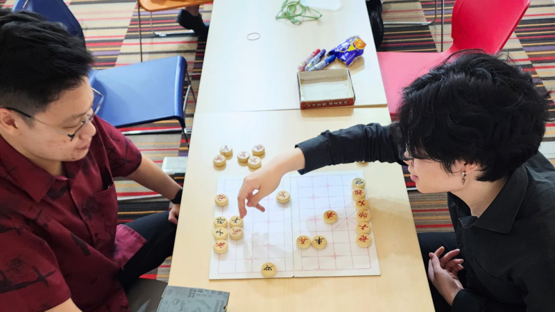 Two people playing Chinese checkers.