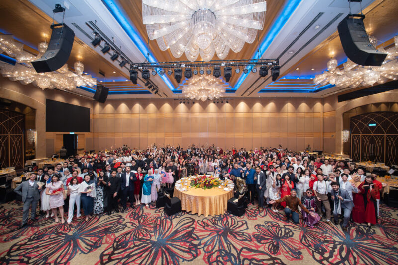A large group of people posing at a formal dinner event.